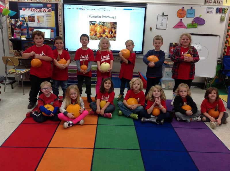 students holding pumpkins