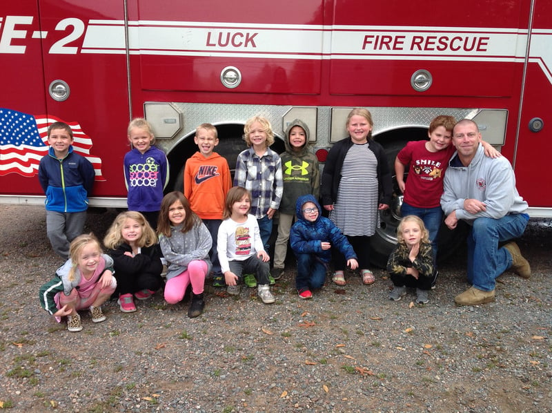 Students posing in front of firetruck
