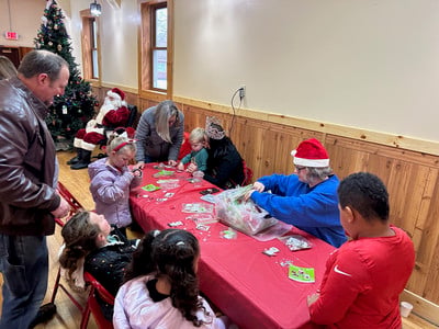 children making crafts with Santa in the background