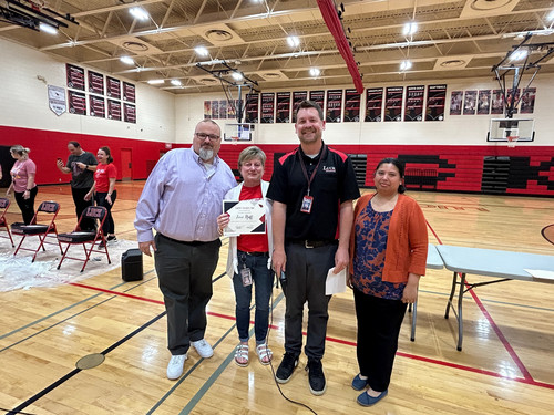 Principal and Superintendent posing with award recipient