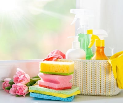 sponges and basket of cleaning bottles